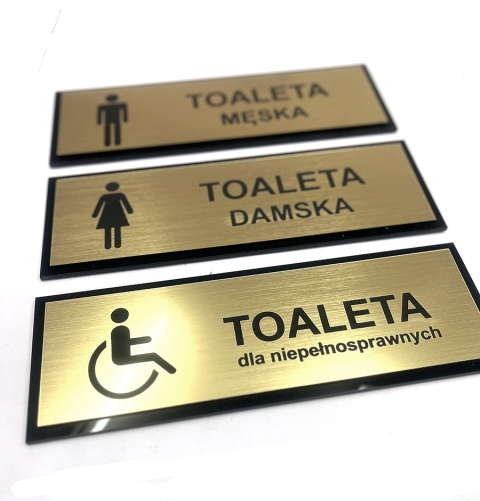 Tabliczka na drzwi TOALETA – męska, damska, dla niepełnosprawnych – złoto szczotkowane + czarne plexi – 21 × 7 cm